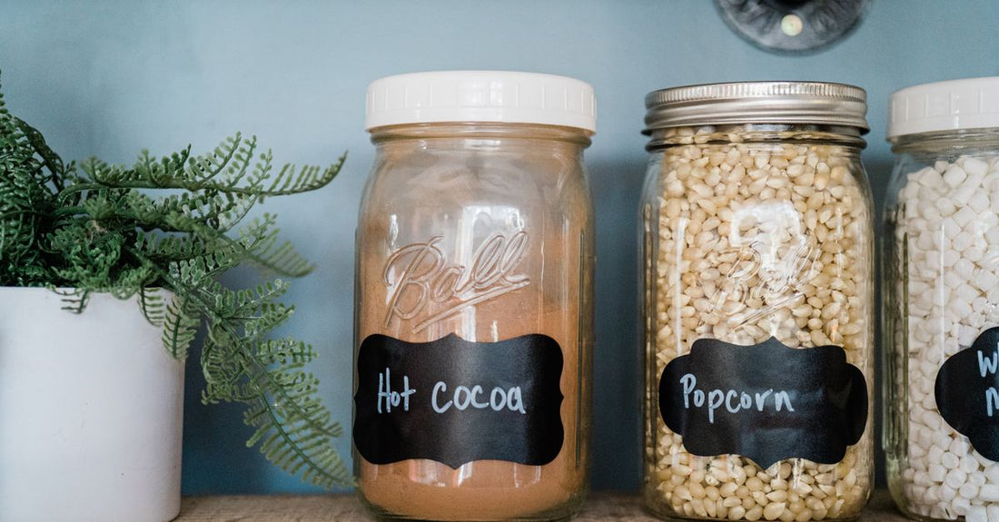 A collection of best everyday vitamins & supplements 2026 in amber glass bottles, arranged on a light wooden surface beside a eucalyptus sprig.