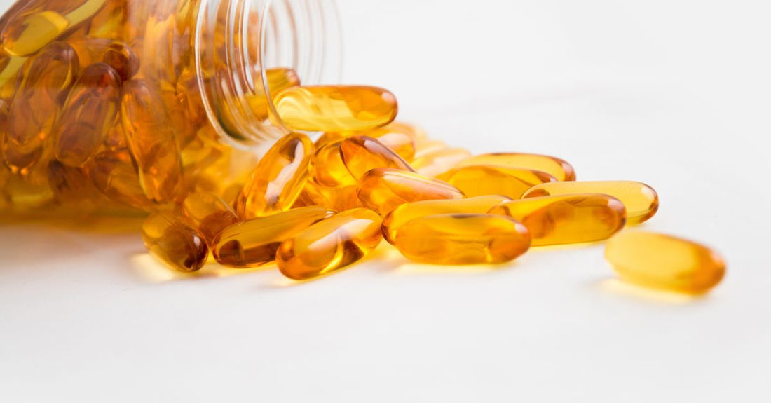 A flatlay of everyday vitamins and supplements including multivitamins, omega-3 capsules, and vitamin D bottles on a neutral background, representing the best everyday vitamins & supplements 2026.