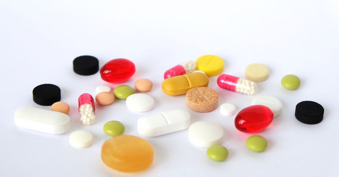 Flatlay of everyday vitamins and supplements bottles on a light surface, illustrating an everyday vitamins & supplements buying guide.