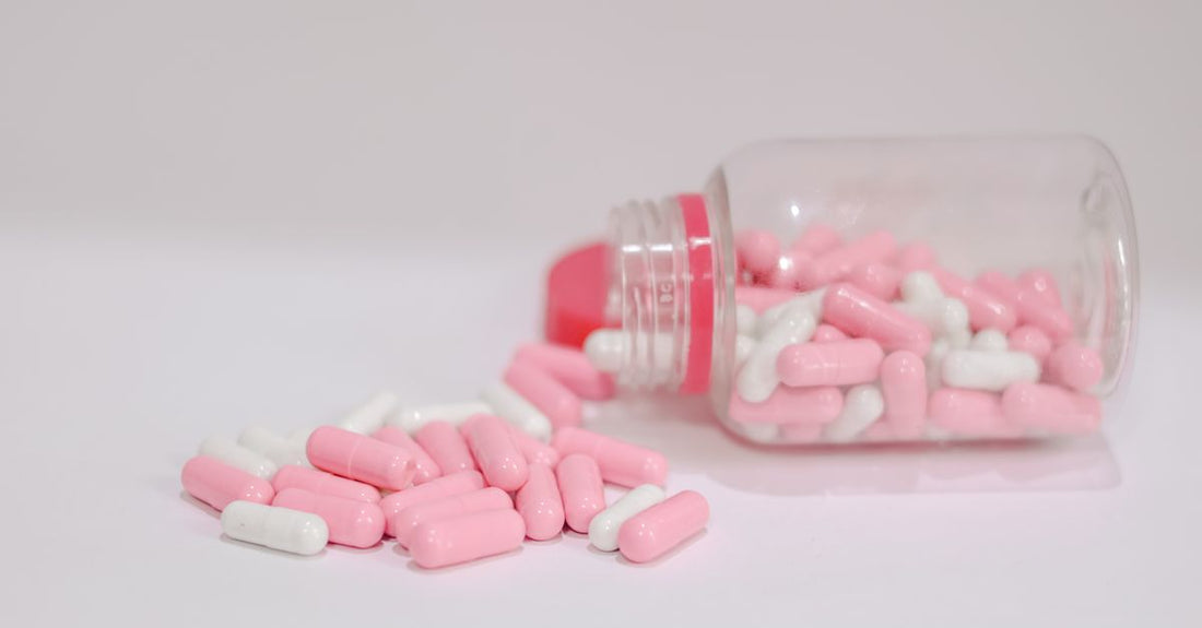 A flatlay of everyday vitamin and supplement bottles and capsules on a light surface, representing the best everyday vitamins & supplements 2026.