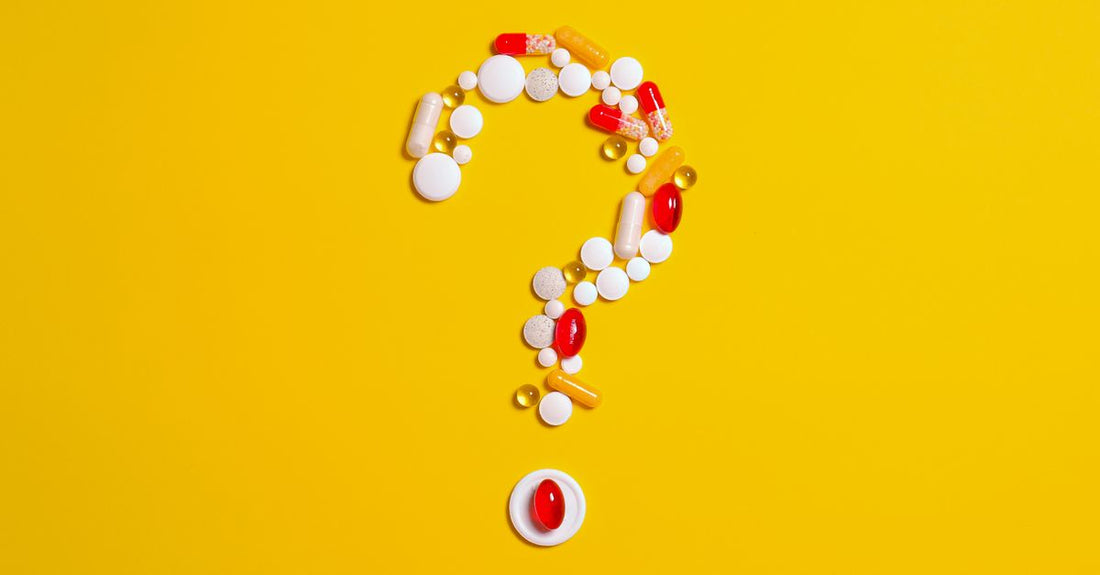 A flatlay of everyday vitamins and supplements bottles on a white table, illustrating an everyday vitamins & supplements buying guide.