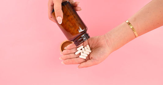 A bottle of vitamin C supplements with citrus fruits on a light background, illustrating how to boost immune system naturally.