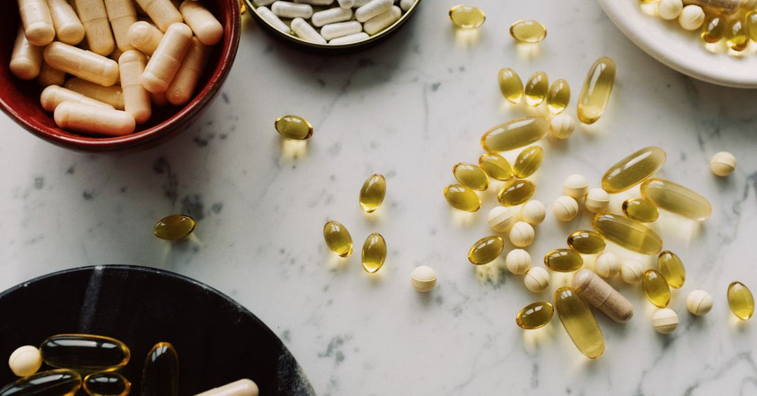 Flatlay of various vitamin and supplement bottles on a white surface, illustrating an everyday vitamins & supplements buying guide.