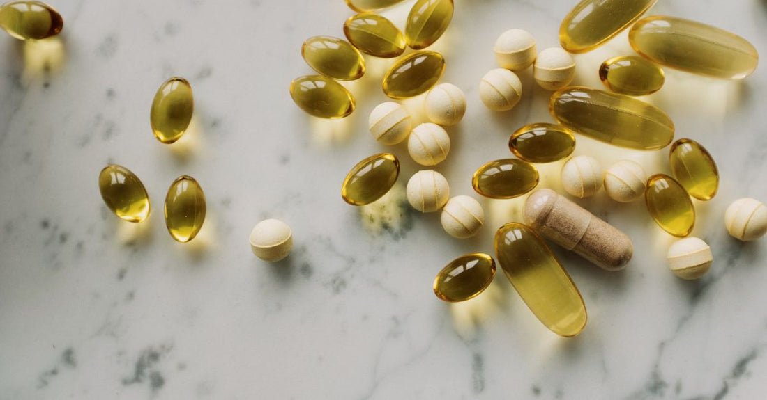A selection of everyday vitamins and supplements like probiotics, omega-3, and multivitamins arranged neatly on a surface, illustrating an everyday vitamins & supplements buying guide.