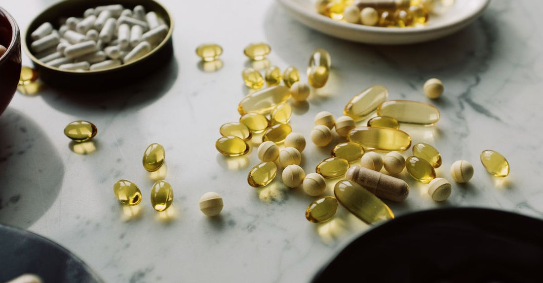 A curated flatlay of best everyday vitamins & supplements 2026, including multivitamin, omega-3, magnesium, probiotic, and vitamin D bottles on a clean marble surface.