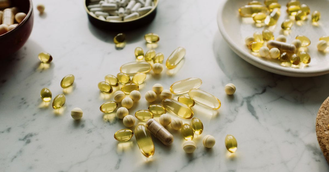 A flatlay of best everyday vitamins & supplements 2026 bottles on a clean surface, showcasing multivitamins, omega-3, and probiotics.