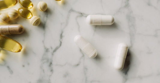 Vitamin C supplements in white capsules on a clean surface, ideal for supporting iron absorption.