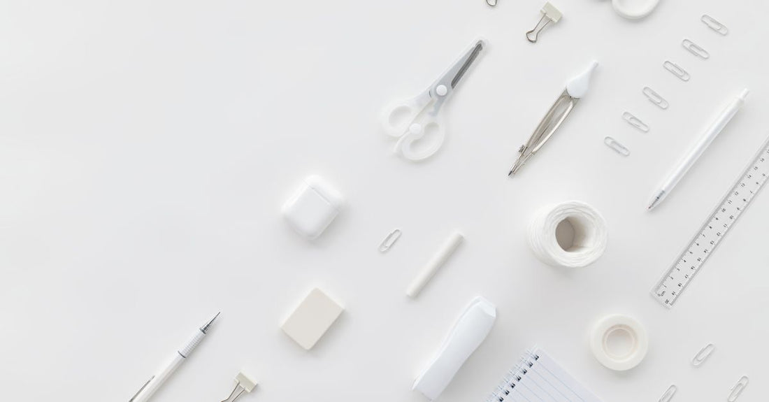 Flatlay of best everyday vitamins & supplements 2026: colourful capsules and tablets arranged neatly on a white surface with a notepad and pen.