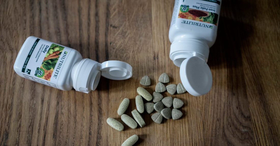 Flatlay of best everyday vitamins & supplements 2026 bottles on a white marble surface in Australia