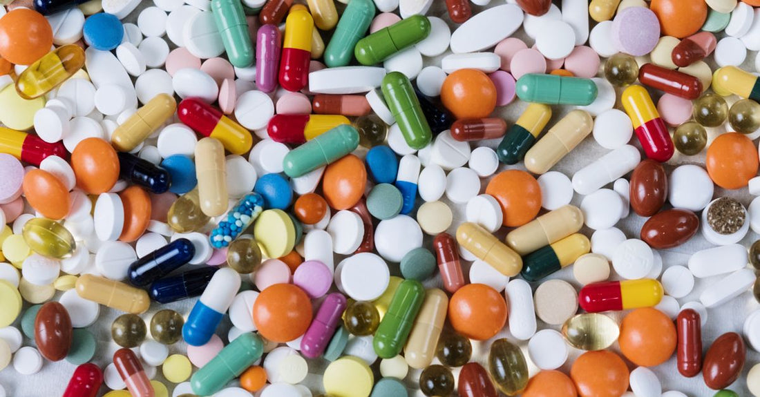 Assortment of vitamin capsules and supplement bottles on a bright surface for everyday vitamins & supplements buying guide