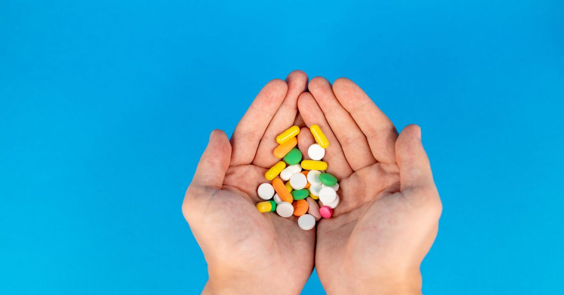 A colourful flatlay of everyday vitamins & supplements bottles and capsules on a bright surface