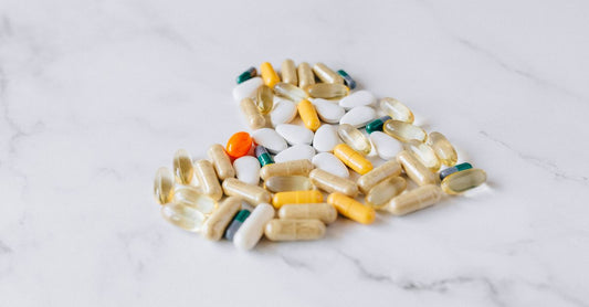 Colourful everyday vitamin and supplement capsules arranged on a clean white surface, representing how to choose the right daily nutrients in Australia.