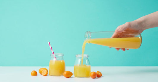 A jar of vitamin C powder on a wooden surface with a measuring spoon, showing the fine crystalline texture of ascorbic acid for how to take vitamin c powder guide.