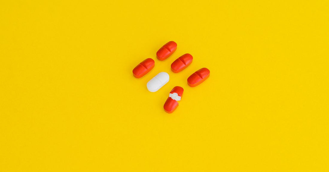 A flatlay arrangement of colourful vitamin and supplement bottles on a bright surface, illustrating an everyday vitamins & supplements buying guide.